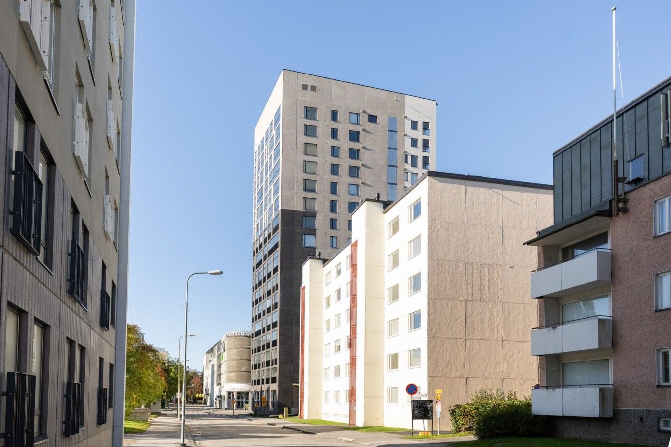 Un edificio de varios pisos con un diseño moderno, que combina espacios residenciales y comerciales.