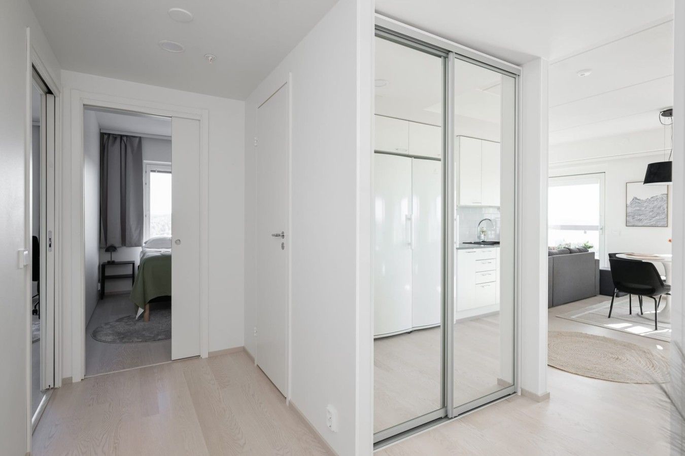Un interior moderno con un dormitorio, un vidrio que da a una cocina y un comedor.