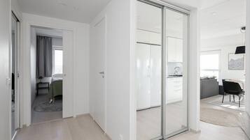 Un interior moderno con un dormitorio, un vidrio que da a una cocina y un comedor.