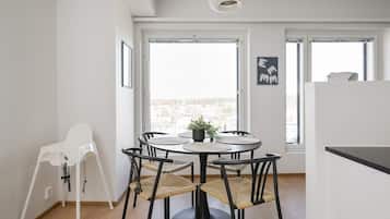 Una cocina moderna con comedor, ventanas amplias y vistas a la ciudad.