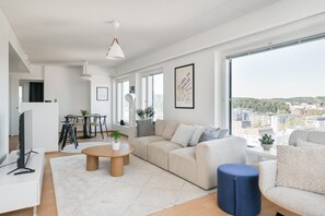 Un salon moderne comprenant un canapé, une table basse et un coin repas avec des chaises et une table.