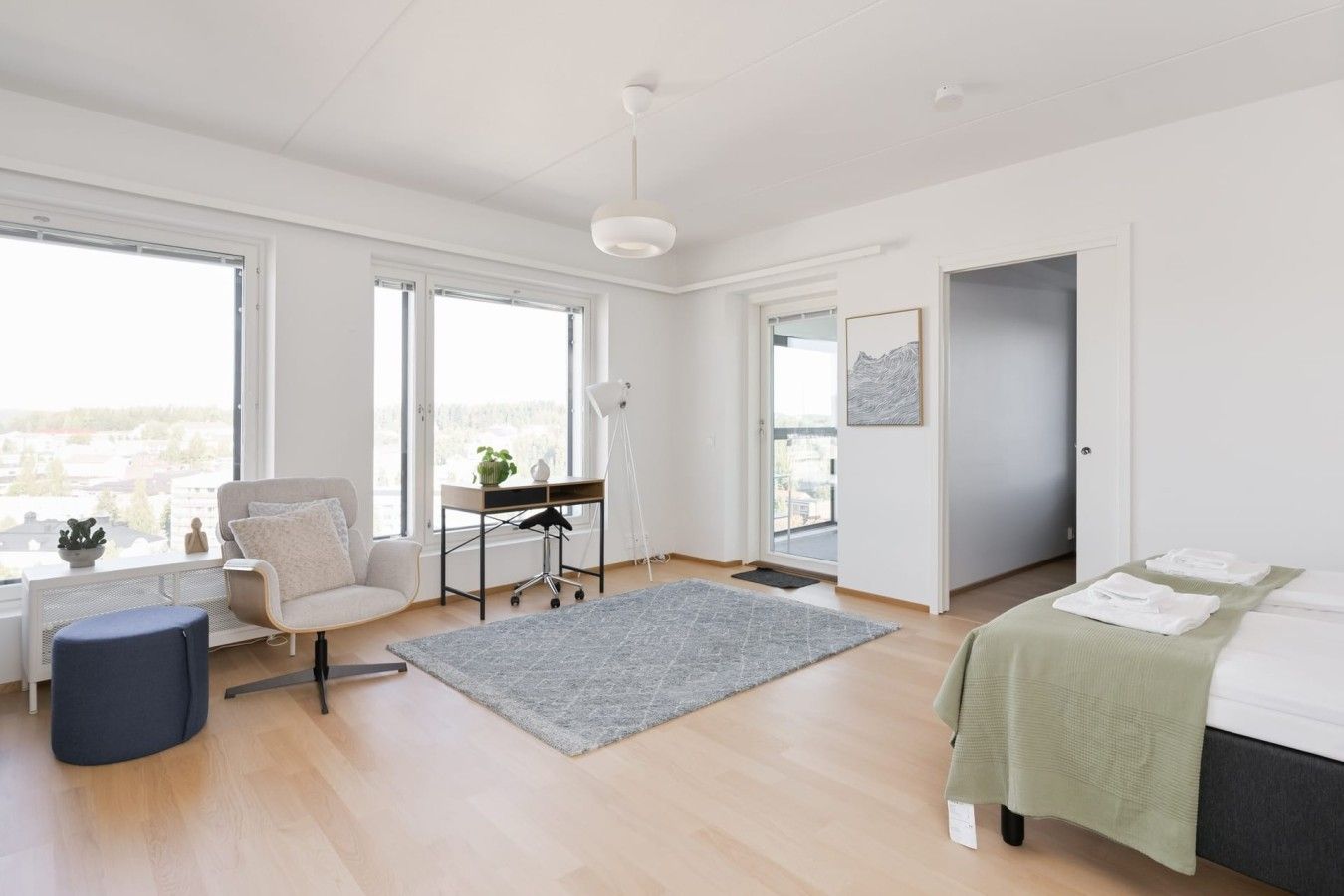 Un dormitorio moderno con cama, escritorio y silla.