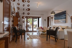 A living room with a sofa, chairs, a coffee table, and a painting on the wall. - Bungalow with 1 bedroom (Playa Blanca, Lanzarote)