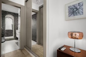 A modern bathroom with a glass shower enclosure, a marble wall, and a framed artwork on the wall. - Rodeo Boutique Townhouse with Private Hot Tub near Puerto Banús (Marbella)