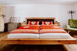A double bed with a wooden frame and a red and white checkered bedspread.