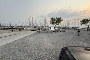 A marina with numerous boats docked, a gravel parking area, and a few trees. - Holiday home with 4 bedrooms (Egernsund)