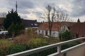 Een woonwijk met huizen, een hoge zendmast en een bewolkte lucht.
