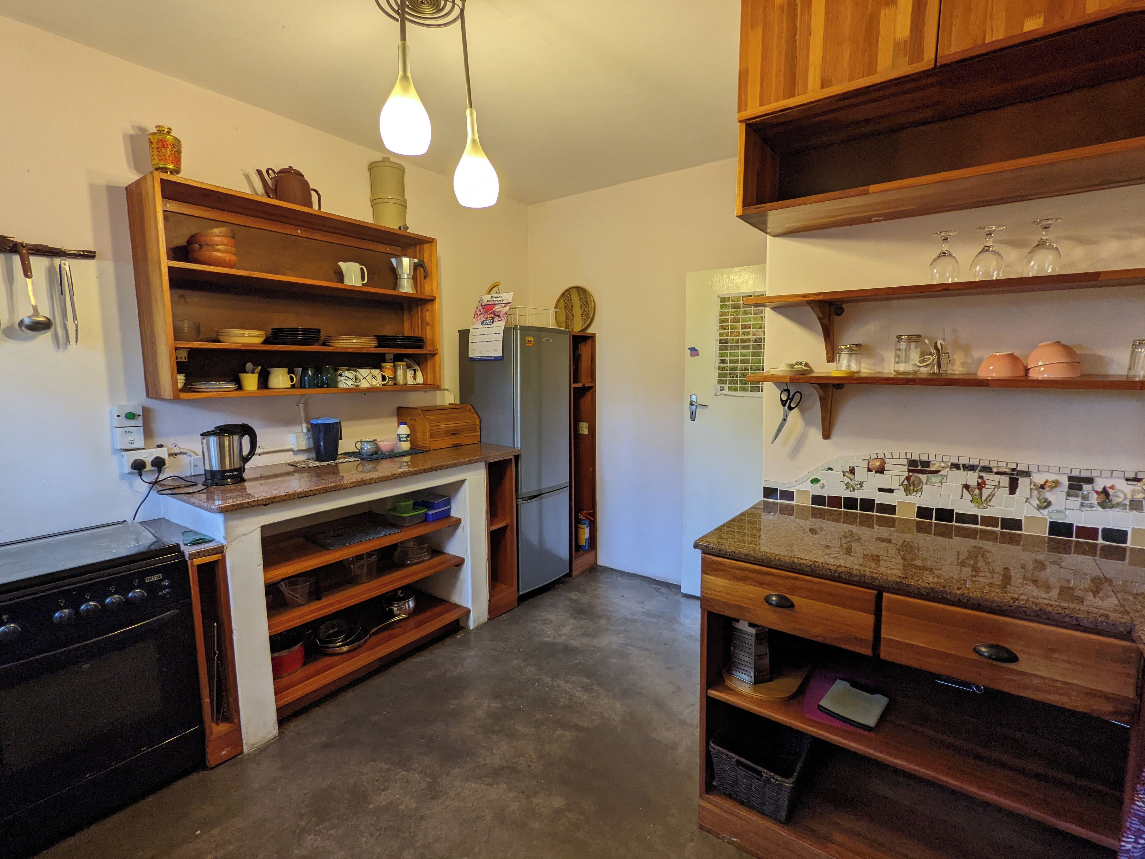 Een keuken met houten kastjes, een koelkast en een betegelde achterwand.