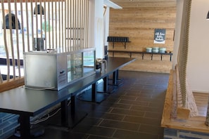 A modern kitchen with a stainless steel refrigerator, a glass display case, and a wooden wall with a chalkboard sign.