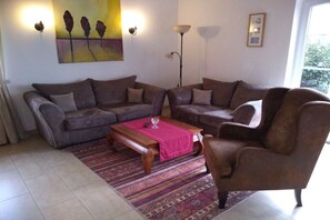 A living room with two sofas, a coffee table, and a rug. - Holiday home with 2 bedrooms (Greetsiel)
