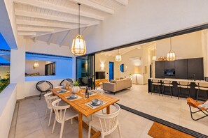 A modern interior with a dining area, kitchen, and living space. - The Bank | Luxe Penthouses | 5 min Mambo&Jan thiel (Willemstad)