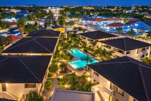 A resort with multiple buildings, a swimming pool, and surrounding greenery. - The Bank | Luxe Penthouses | 5 min Mambo&Jan thiel (Willemstad)