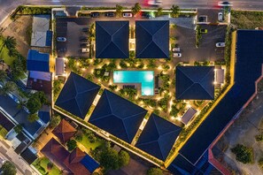 An aerial view of a resort with a swimming pool, multiple buildings with solar panel roofs, and a parking area. - The Bank | Poolside Apartment. | Mambo & Jan Thiel (Willemstad)