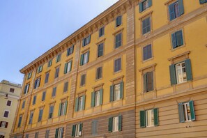 A multi-story building with a yellow facade and green shutters. - Vatican City View | 2 Bedrooms & 2 Bathrooms (ROMA)