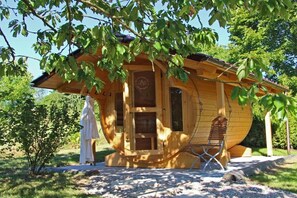 A wooden cabin with a circular design, a porch, and a swing chair. - Canadian Luxury Chalet (Leisel)