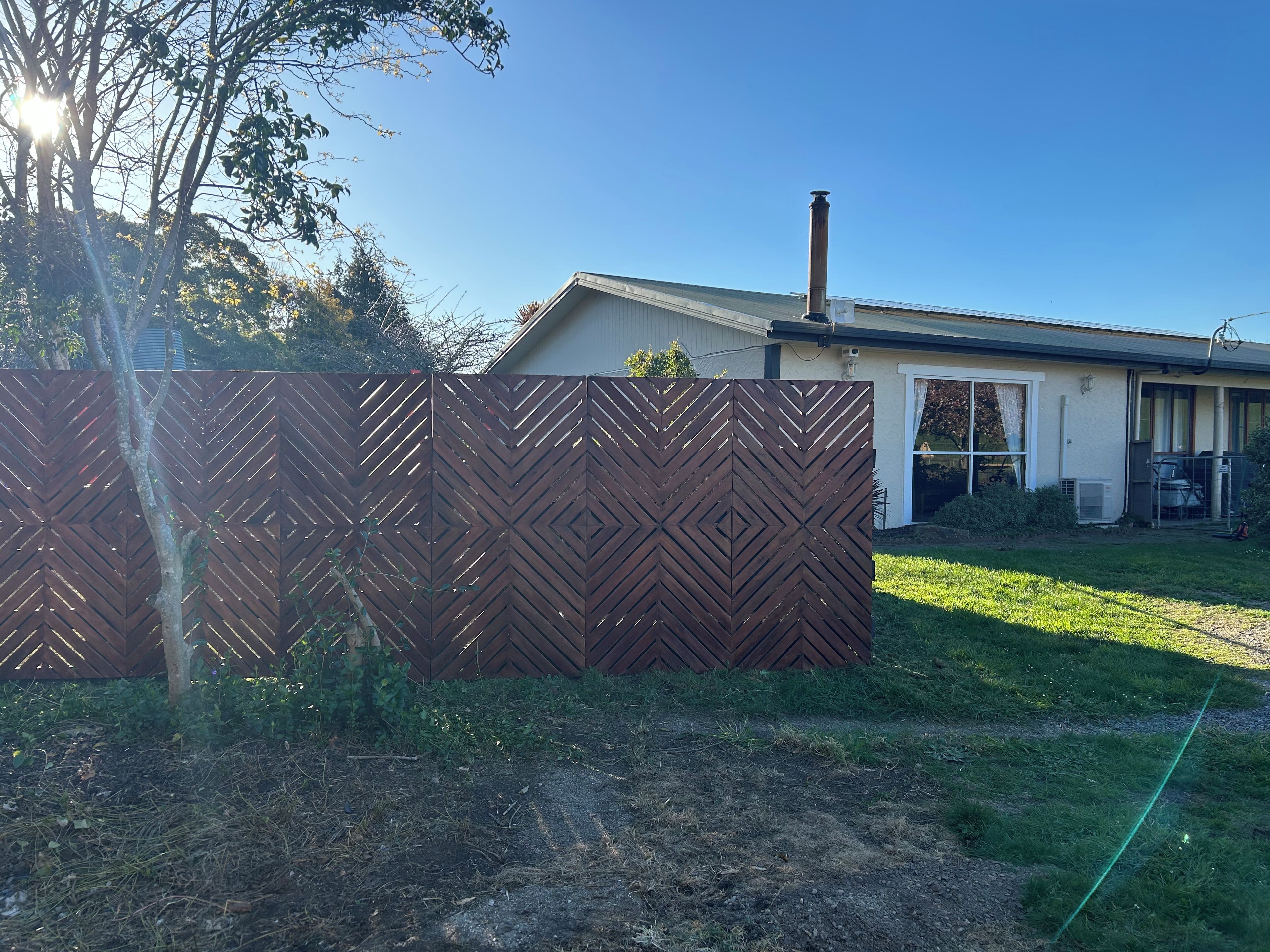 A residential property with a fenced backyard, a chimney, and a garage.