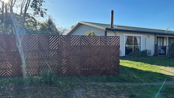 A residential property with a fenced backyard, a chimney, and a garage.