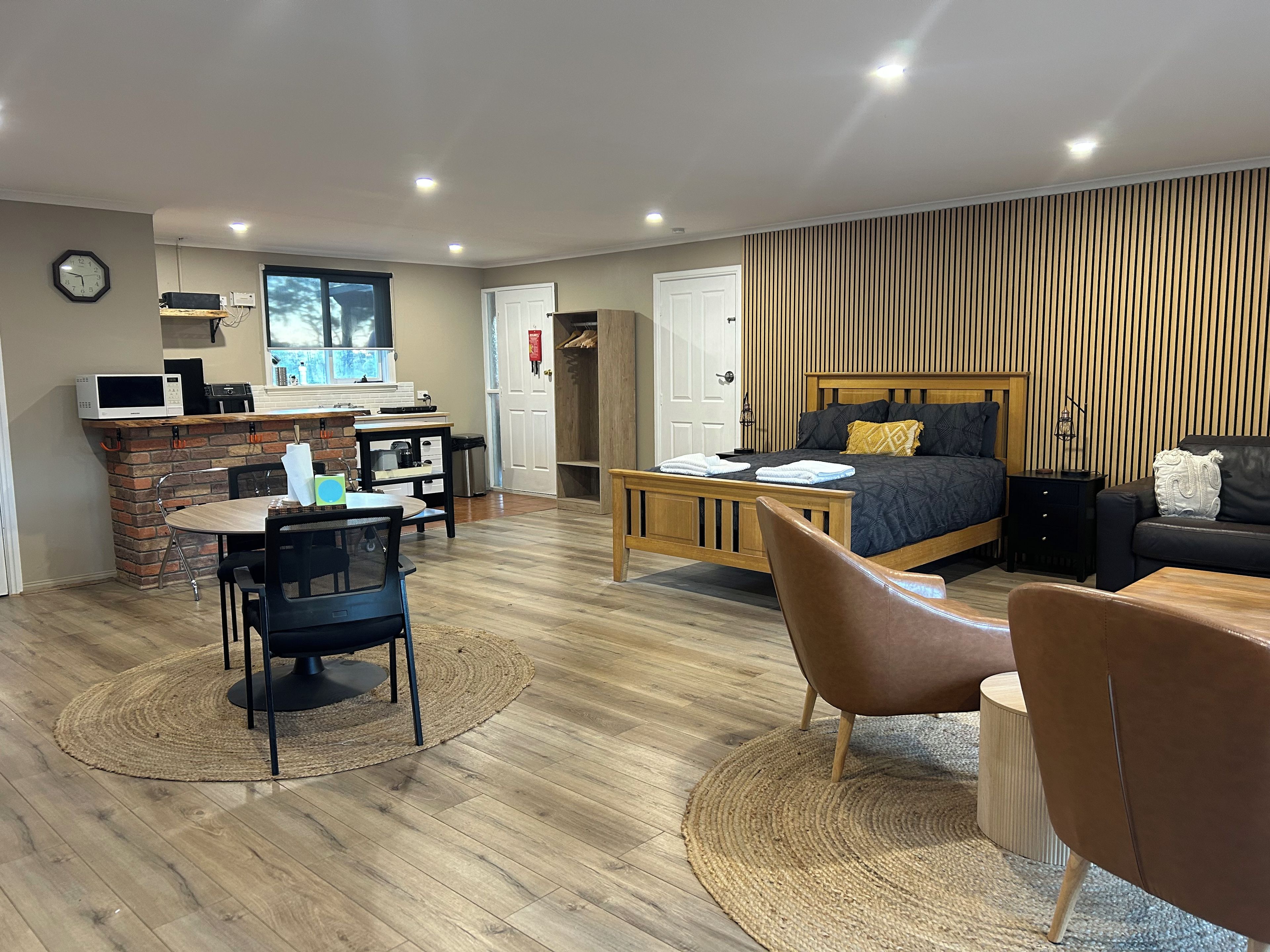 Un dormitorio moderno con cama, escritorio y zona de comedor.