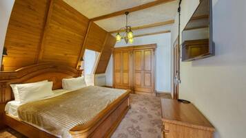 Un dormitorio con cama de madera, armario y televisor montado en la pared.