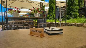 A table with a 'RESERVED' sign, wicker chairs, and a white tablecloth.