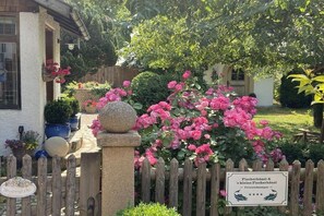 A wooden fence with a sign indicating a fishing house and a small pond. - "s kleine Fischerhäusl" (Utting\/Ammersee)