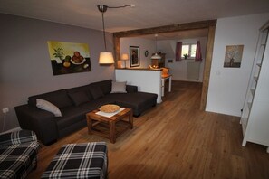 Ein Wohnzimmer mit einer Couch, einem Couchtisch und einem Bild an der Wand.