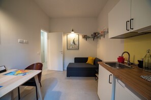 A compact kitchen with a dining area, a sofa, and a small table. - BELLOSGUARDO HILL APARTMENT, FLORENCE (Toscana)