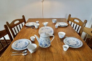 A wooden dining table set with blue floral china, including plates, cups, and a teapot. - Lindenhof Holiday Apartment No. 2 (Wenningstedt-Braderup)
