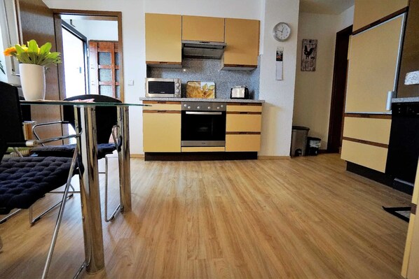 A compact kitchen with a stove, oven, and a small countertop. - Apartment 'Festungsblick' with Terrace, Garage and Private Entrance (Koblenz)