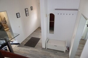 Ein modernes Interieur mit einem Glastisch, einer Bank und einem Wandheizkörper.