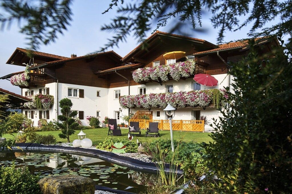A hotel with a garden, a pond, and outdoor seating.