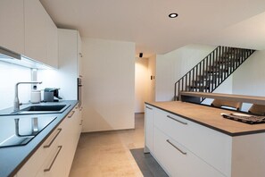 A modern kitchen with a built-in stove, a sink, and a countertop. - Holiday apartment Villa Alpjuwel-Mondblick (Oberstdorf)