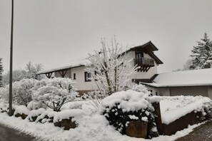 A two-story building with a snow-covered roof and a balcony. - Holiday apartment with 1 bedroom (Walsdorf-Zilsdorf)