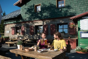 A wooden table with a basket, a bottle, and a plate of food. - Holiday apartment with 1 bedroom (Fichtelberg)