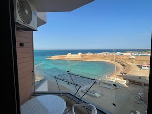 Un balcó amb vista a la platja, un tendal per estendre roba i un ventilador.