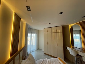 Een hotelkamer met een bed, een kledingkast, een spiegel en een bureau.