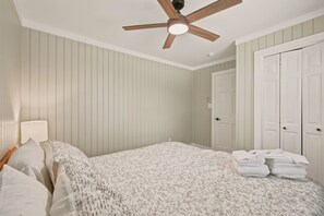 A bedroom with a bed, a ceiling fan, and a door. - 3800 Sq Ft Lodge- Ski Shuttle, Hot Tub & Sauna, 5BR Sleeps 16 (Sugar Mountain)