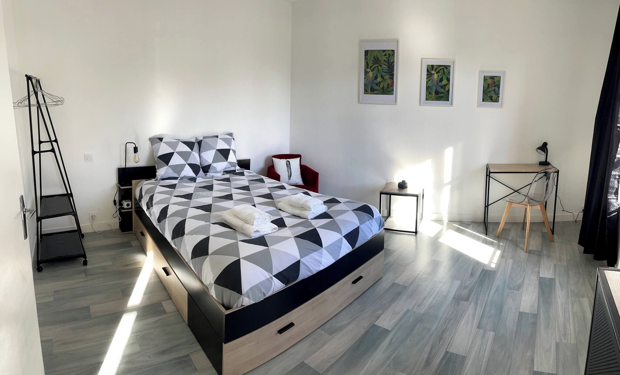 Un dormitorio moderno con una cama, un escritorio y una silla.
