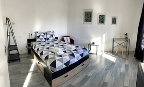 Un dormitorio moderno con una cama, un escritorio y una silla.