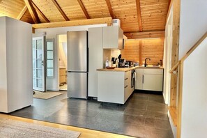 A modern kitchen with a wooden ceiling, stainless steel appliances, and a view to the outside. - Apartment in Herrsching with swimming pool (Herrsching)