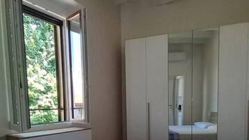 A bedroom with a bed, a window, and a wardrobe.