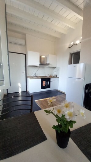 A modern kitchen with white cabinets, a built-in oven, and a refrigerator.