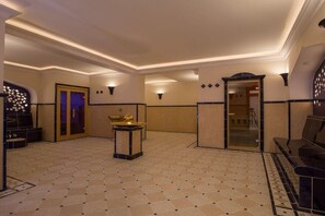 Un hall d’hôtel comprenant un comptoir d’enregistrement, un espace salon et une fontaine décorative.