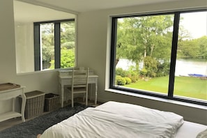 A bedroom with a large window, a bed, a desk, and a chair. - Holiday home with 3 bedrooms (Ganderkesee)