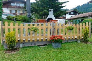 A wooden fence with flower boxes and a small tree. - Holiday apartment with 2 bedrooms (Obermaiselstein)