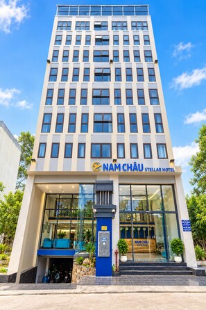 Un moderno edificio de hotel con un letrero llamativo para Nam Châu Stellar Hotel.