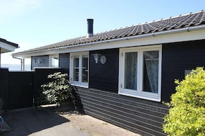 A black house with a tiled roof, white windows, and a chimney. - Top Wadden Sea holiday home (Esbjerg)