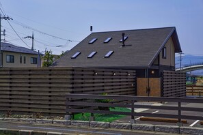 A modern building with a sloped roof, multiple skylights, and a wooden facade. - IZA moriyama (Moriyama-shi)