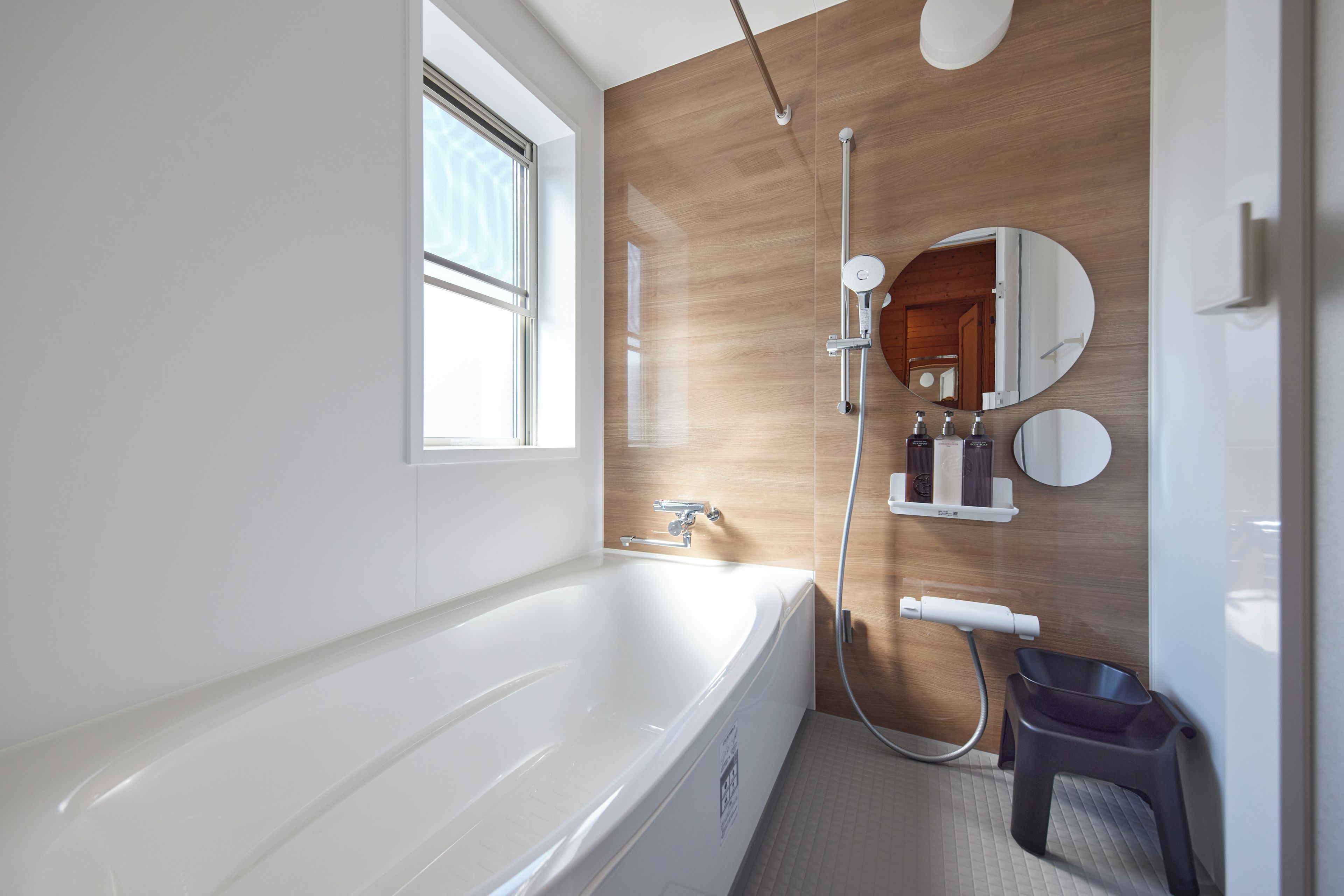 A modern bathroom with a bathtub, a shower, and a vanity with a mirror.