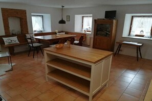 A spacious living area with a dining table, chairs, a fireplace, and a television. - at the Haslinger holiday farm (Winzer)